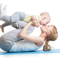 young mother does fitness exercises together with kid boy